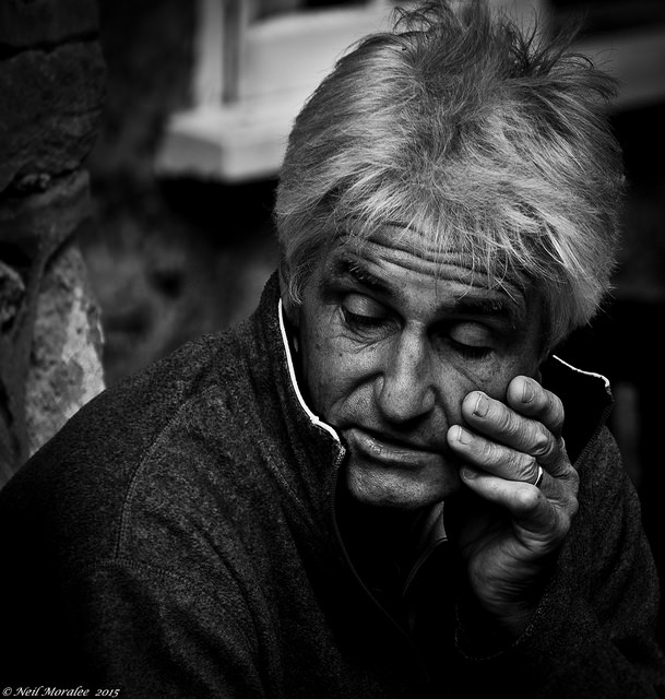 An old man sitting on the street