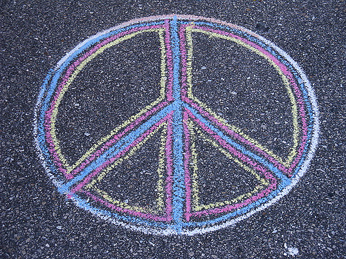 An International Peace Symbol drawn with multicolored chalk on a blacktop