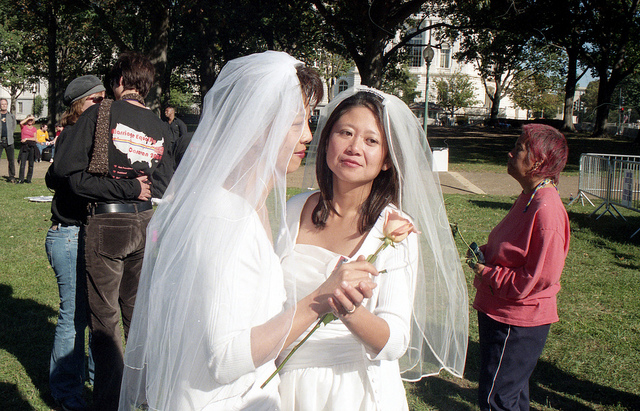 Two women in wedding dresses who have just been happily married