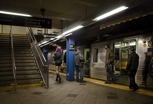 A prostitute standing next to a platform at the subway station