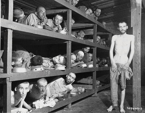 Many jewish men being held in a concentration camp. They are so skinny that their rib cages and face bones are very evident