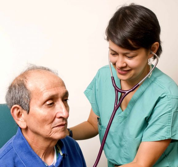 A nurse checking the heart rate of an elderly man
