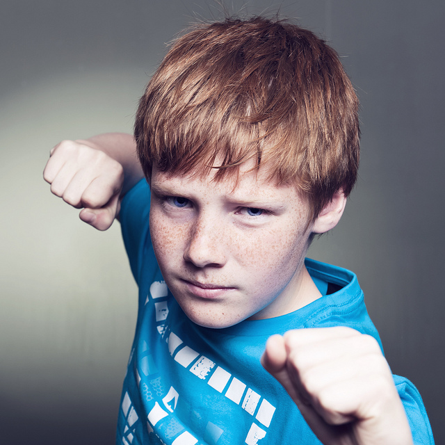 A young boy posed with his fists up, ready to fight
