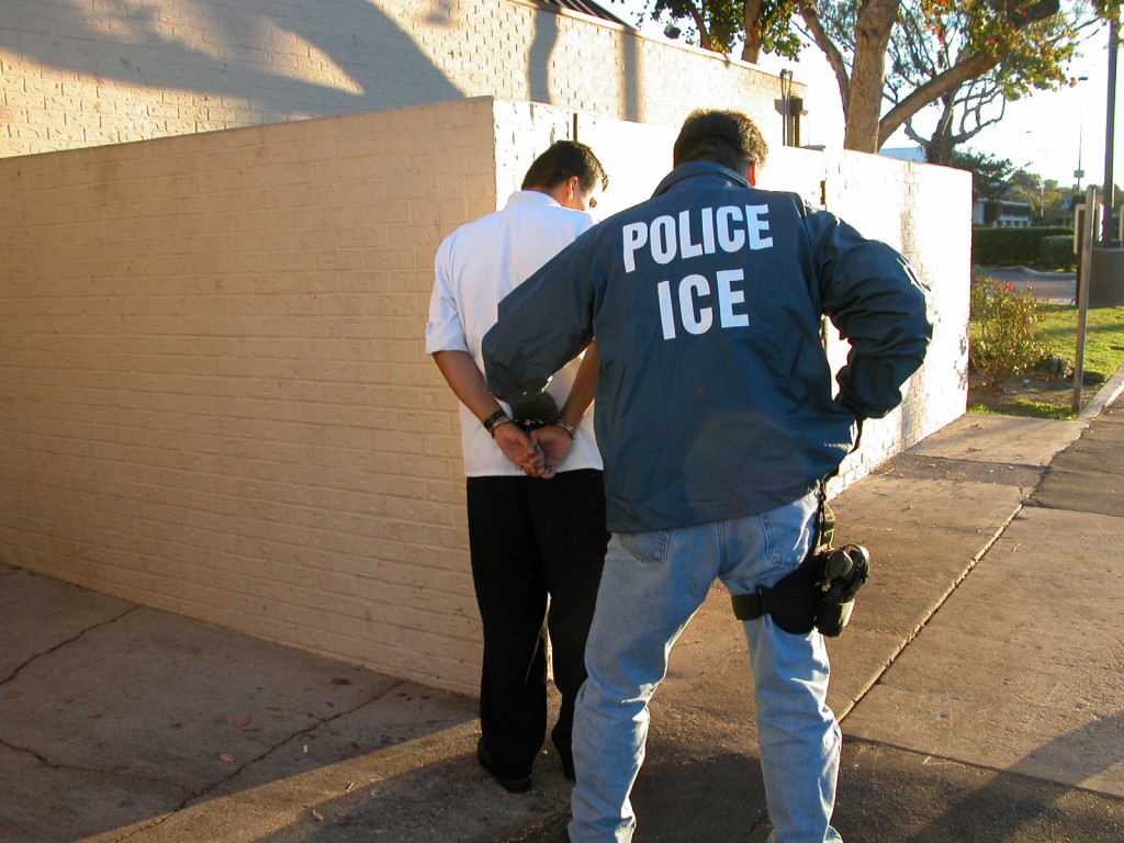 A cop arresting a man outside a building