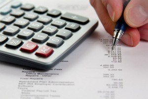 A man analyzing financial data with a men and calculator