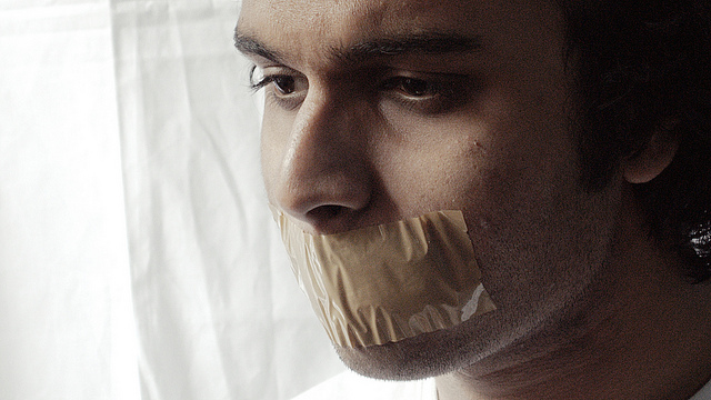 A man with a piece of tape over his mouth