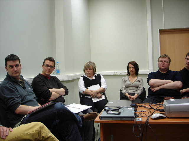 Team members listening to a speaker