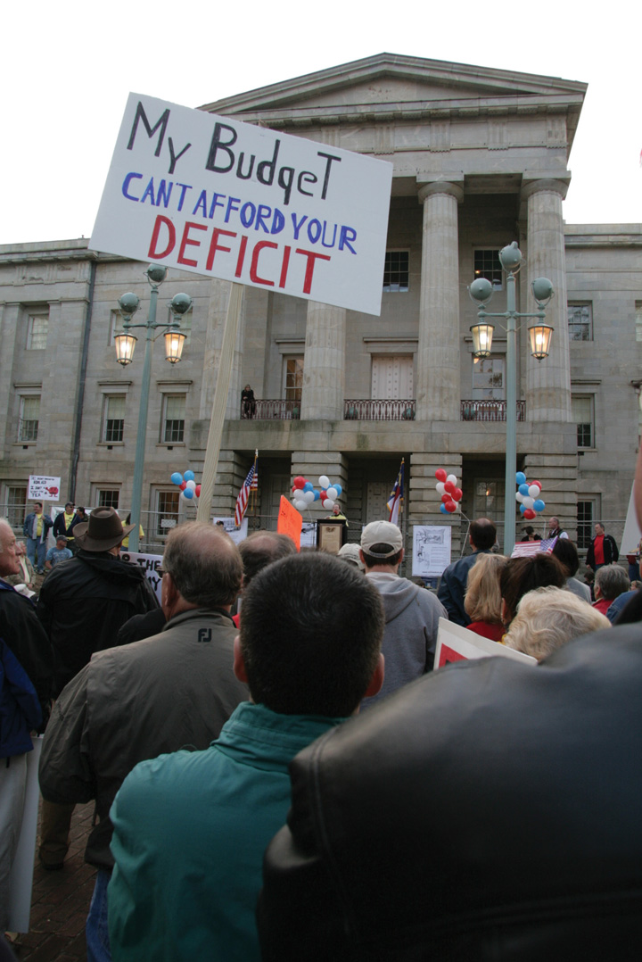 A tea party rally where a man holds a sign that says