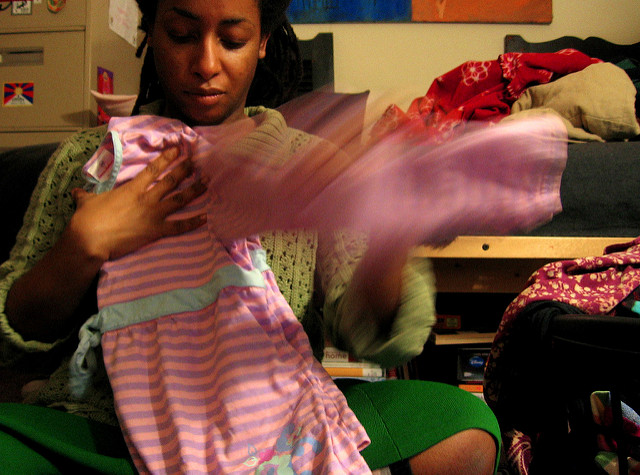 A woman folding her child's clothing