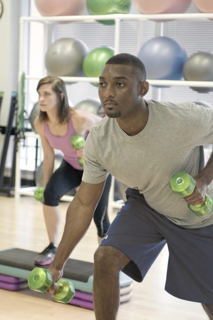 Two people with weights doing aerobic exercise.