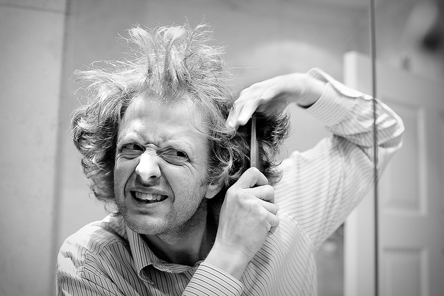 A man trying to tame his crazy hair