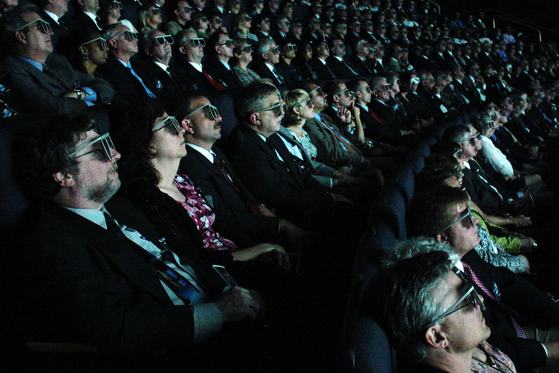 image of a group of people in an indoor venue viewing 3D Imax clips with 3D movie glasses