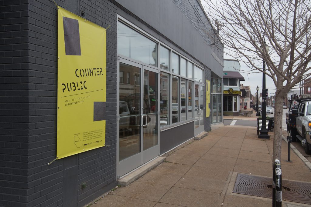 Poster on the side of a grey building in Benton Park West, St. Louis, Missouri that prominently reads "Counter Public" as an advertisement for an arts festival.