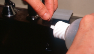 glass slide being rinsed with distilled water