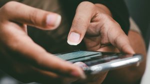 Two hands texting on a mobile phone