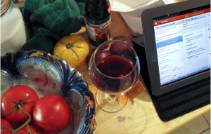 Closeup of table with tomatoes, wine, and an iPad.
