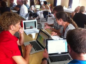 Group of people sitting at a table using laptops.