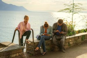 Parents looking at phones while daughter waits