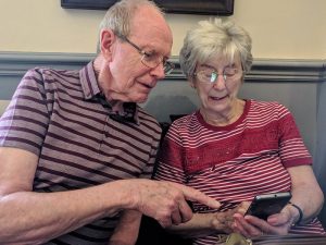 Elderly couple using a phone.