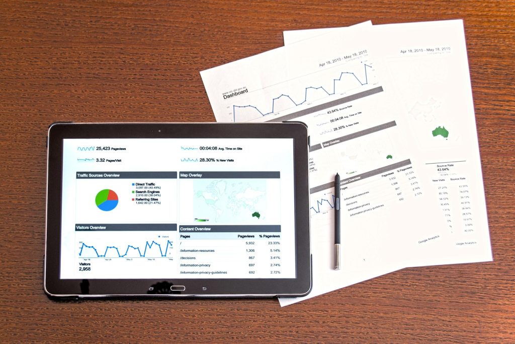 Paper company reports and a digital report in a tablet.