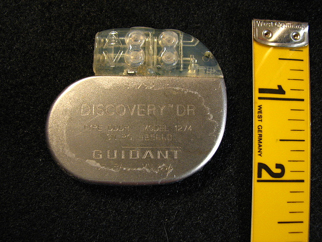 Pacemaker next to a ruler, showing that it is no bigger than two inches