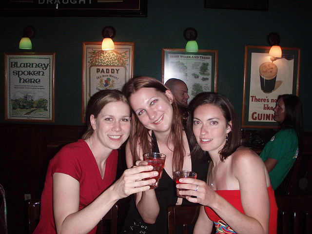 Three women taking shots at a 21st birthday party