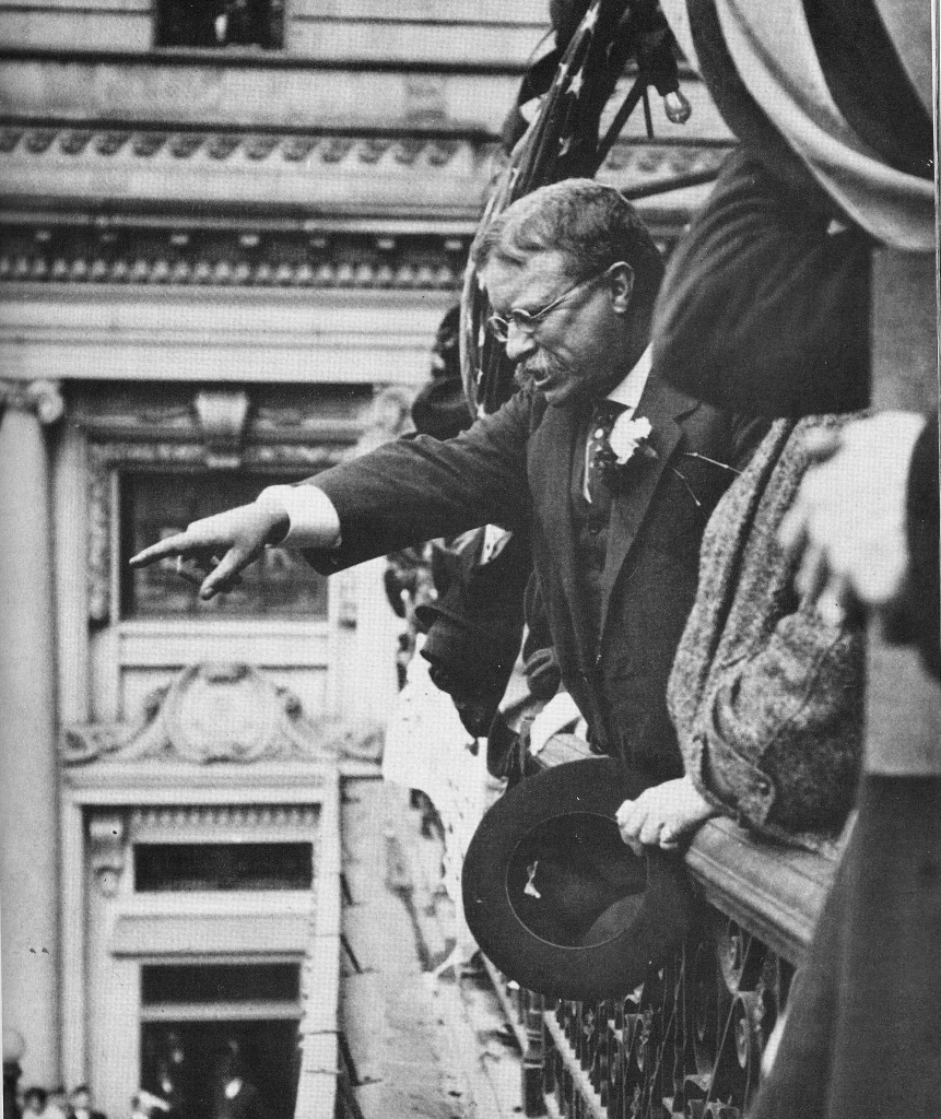 Teddy Roosevelt pointing at the crowd outside a balcony